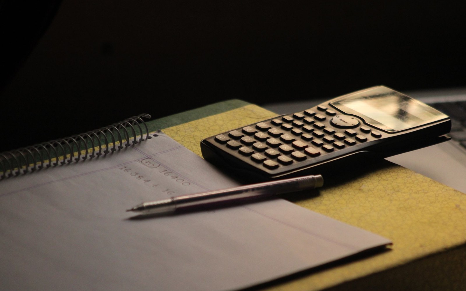 A scientific calculator resting on an open notebook